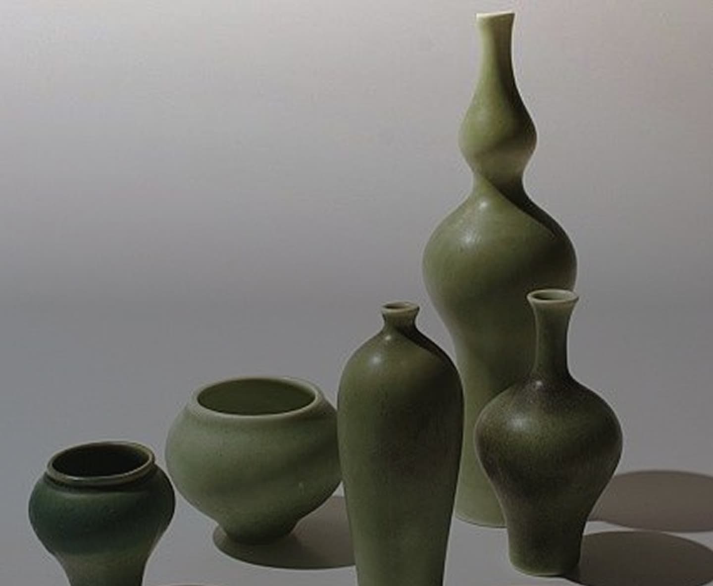 A group of dark green glazed vases